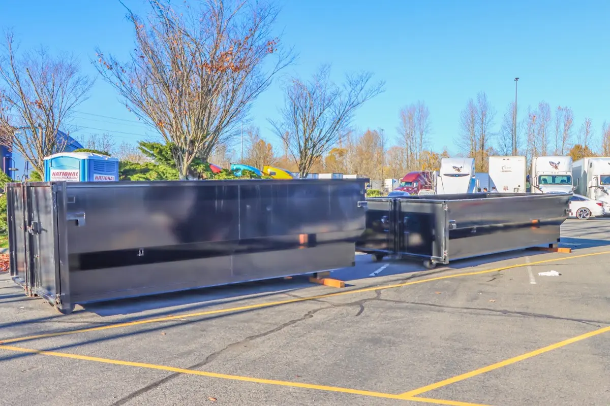 Professional dumpster rental service with roll-off container on residential driveway in Asbury